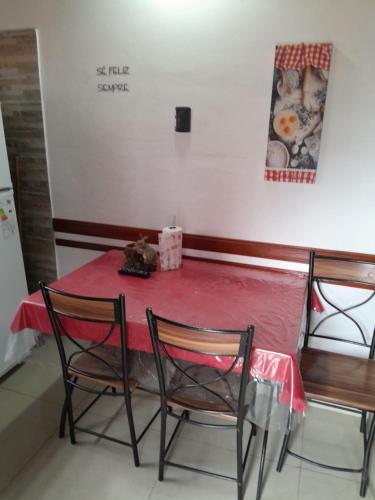 a table with two chairs and a table with a red table cloth at 6 luceros in Santa Teresita