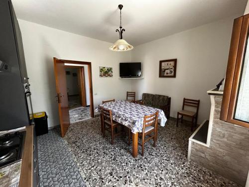 uma sala de jantar com uma mesa e cadeiras e uma televisão em La lavanda em Controguerra