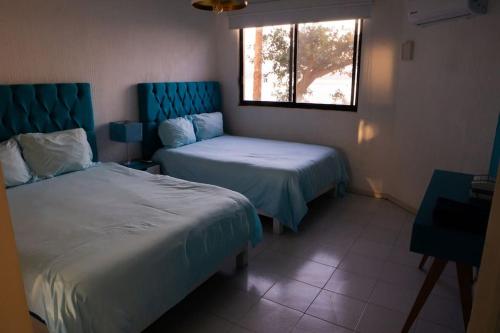 a hotel room with two beds and a window at Precioso depto con inigualable vista, Aqua Beach. in Tequesquitengo