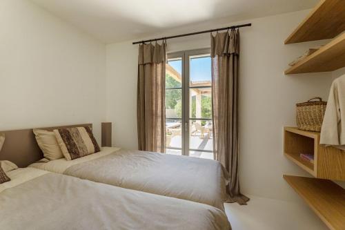 une chambre avec deux lits et une fenêtre dans l'établissement Maison Emilisa, à Paradou