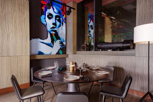 a table in a restaurant with a painting on the wall at Baku Marriott Hotel Boulevard in Baku