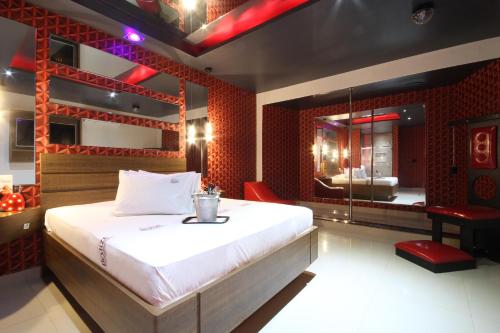 a bedroom with a large bed and a mirror at Motel Deslize Limeira 3 in Limeira