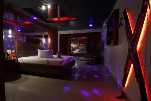a room with a bed in a room with purple lights at Motel Deslize Limeira 3 in Limeira