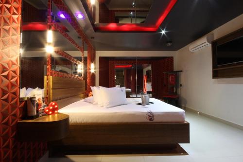 a bedroom with a large bed with a red light at Motel Deslize Limeira 3 in Limeira