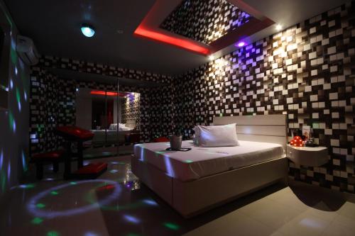 Motel Deslize Limeira 3 في ليميرا: غرفة نوم مع سرير في غرفة مع أضواء