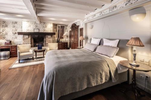 um quarto com uma cama grande e uma lareira em Hotel De Orangerie by CW Hotel Collection em Bruges