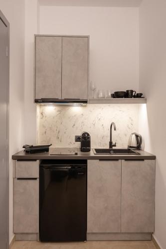 a kitchen with a sink and a dishwasher at Nastram Suites Oia in Oia