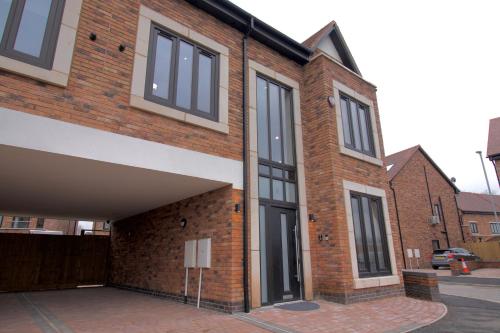 a brick building with black windows on a street at Spacious 6 bedroom House - Sleeps 11, Convenient Location, Perfect for FAMILIES in Birmingham