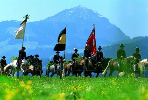 a group of people riding horses with flags on them at Wellness Pension Hollaus in Kirchberg in Tirol