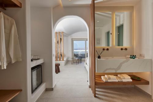 a bathroom with a tub and a sink and a mirror at Phos The Boutique in Akrotiri