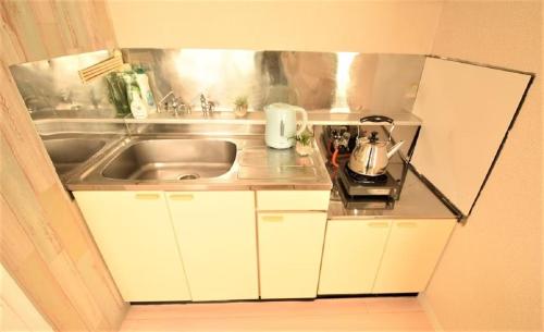 una pequeña cocina con fregadero y microondas en Sapporo - Apartment - Vacation STAY 16455, en Sapporo