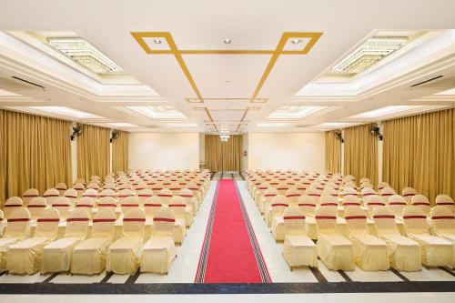 an empty lecture hall with a red carpet and chairs at Hotel Merrytale in Kurinjippādi