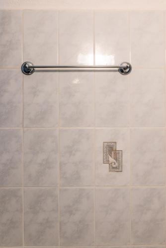 a shower with a tile wall with a hand gesture at Blue Hug Apartments in Plataria