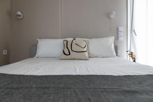a white bed with two pillows on top of it at Blue Hug Apartments in Plataria