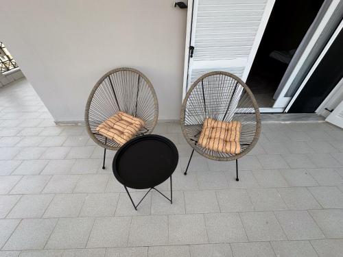 two chairs sitting on a porch next to at Blue Hug Apartments in Plataria