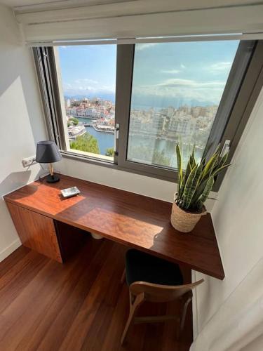 a desk in a room with a large window at Gioma Luxury Suites - Lake View - Jacuzzi in Agios Nikolaos