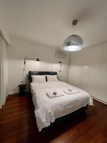 a bedroom with a white bed with two towels on it at Gioma Luxury Suites - Lake View - Jacuzzi in Agios Nikolaos