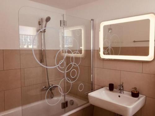 a bathroom with a sink and a shower with a mirror at The Holiday Home Davos in Davos
