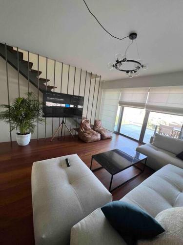 a living room with a couch and a tv at Gioma Luxury Suites - Lake View - Jacuzzi in Agios Nikolaos
