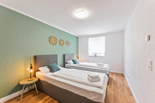 2 camas en una habitación con paredes verdes en Sali Homes - Residenz zum Breitenauer See, en Obersulm