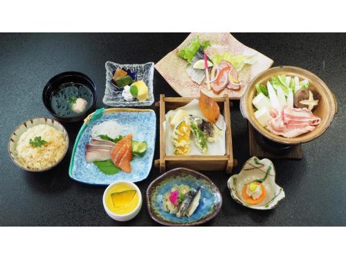 un groupe de plaques alimentaires sur une table dans l'établissement Ikoi no Mura Shimane - Vacation STAY 27451v, à Kyōmendao