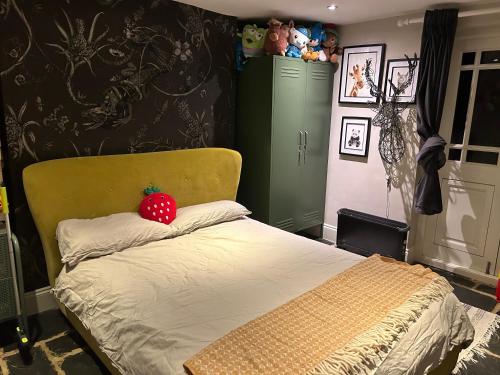 a bedroom with a bed with a strawberry on the pillow at 1 bed garden flat Islington in London
