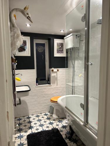 e bagno con doccia, vasca e servizi igienici. di 1 bed garden flat Islington a Londra