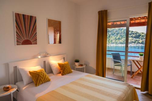 a bedroom with a bed with a view of the ocean at Apartmani Matiša in Lastovo