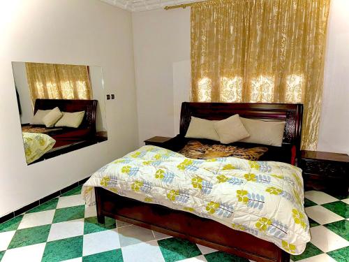 a bedroom with a large bed and a mirror at Mini villa in Oujda