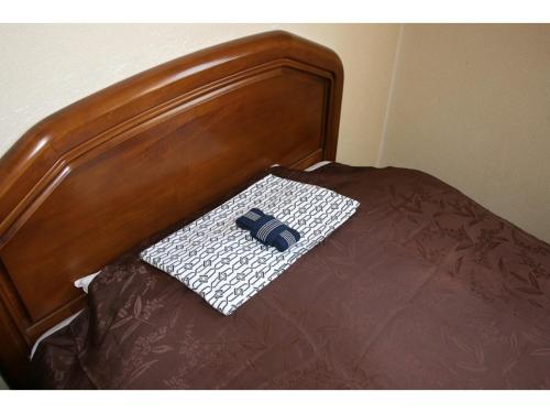 a bed with a wooden head board with a pillow on it at Hotel Tetora Yunokawaonsen - Vacation STAY 30586v in Hakodate