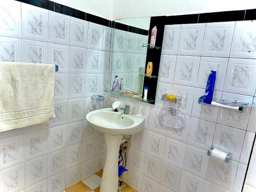 ein weißes Badezimmer mit einem Waschbecken und einem Spiegel in der Unterkunft Mini villa in Oujda