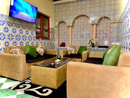 a living room with couches and a flat screen tv at Mini villa in Oujda