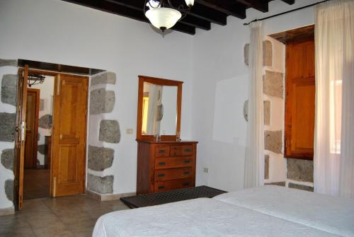 a bedroom with a bed and a dresser and a mirror at Casa Rural Los Suárez in Agüimes