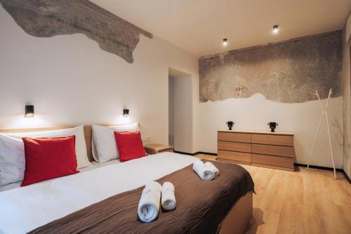 una camera da letto con un grande letto bianco con cuscini rossi di Hviezdoslavova Apartments, Trnava Centre, Parking & Breakfast available a Trnava