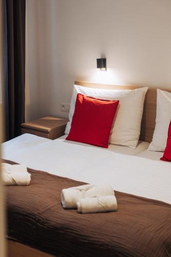 a bedroom with two beds with red and white pillows at Hviezdoslavova Apartments, Trnava Centre, Parking available in Trnava