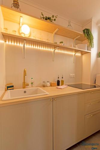 - une cuisine avec un évier et un comptoir éclairé dans l'établissement Beethoven - St Michel - Métro - Tram - Stadium, à Toulouse