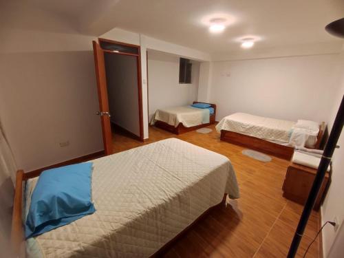 a room with two beds and a door to a bedroom at casa edad dorada in Cusco