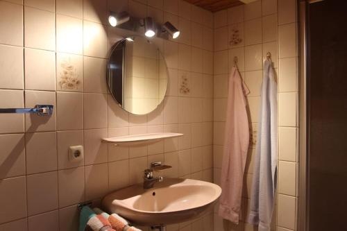 La salle de bains est pourvue d'un lavabo et d'un miroir. dans l'établissement Ferienwohnung am Hof in Inzell, à Inzell