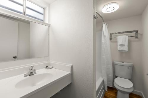 uma casa de banho branca com um lavatório e um WC em Ambassador Lake Tahoe em South Lake Tahoe