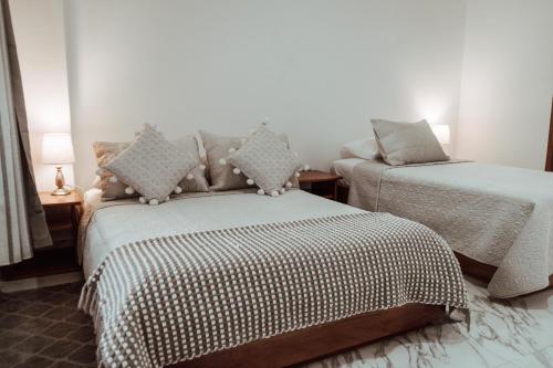 a bedroom with two beds and a table with lamps at HOTEL AYRE By Baltra in Puerto Ayora