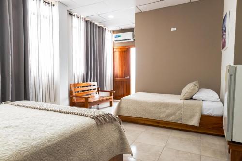a hotel room with two beds and a chair at HOTEL AYRE By Baltra in Puerto Ayora