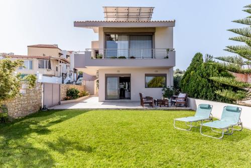 a view of a house with two chairs in the yard at Oikia Eftichia in Skalánion