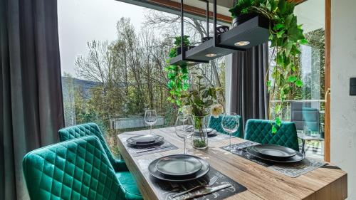 a dining room with a table and chairs and a large window at LOFT MOUNTAIN Apartament Szklarska Poręba in Szklarska Poręba