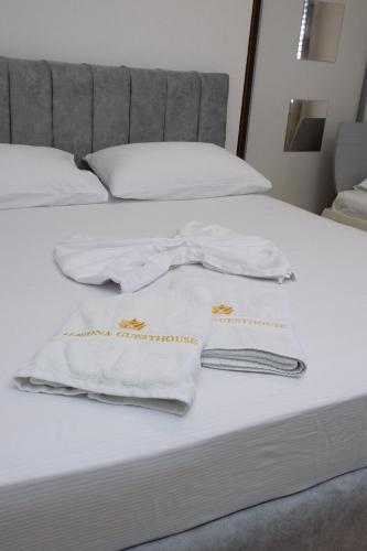 two white towels are sitting on top of a bed at ALBJONA GUESTHOUSE TIRANA in Tirana