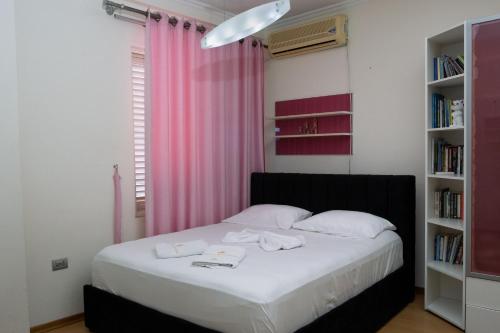 um quarto com uma cama com uma cortina rosa em ALBJONA GUESTHOUSE TIRANA em Tirana