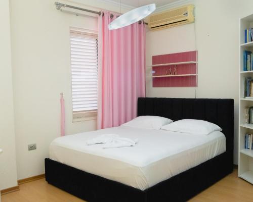 a bedroom with a bed with a pink curtain at ALBJONA GUESTHOUSE TIRANA in Tirana