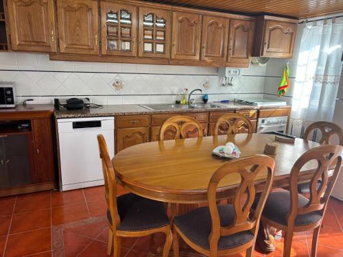 a kitchen with a wooden table and wooden cabinets at White House in Piódão