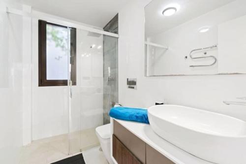 a white bathroom with a sink and a shower at VillaHeLena in Orihuela Costa