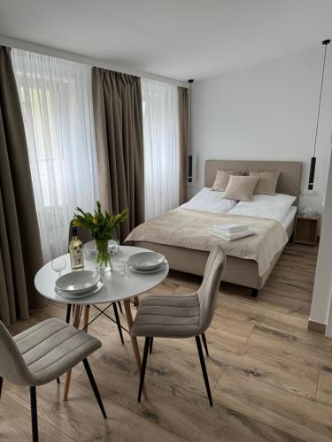 a bedroom with a bed and a table and chairs at Apartamenty Misdroy Parking Gratis 250 m od plaży in Międzyzdroje