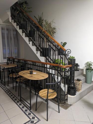a restaurant with tables and chairs next to a staircase at Penzion Grand Nymburk in Nymburk